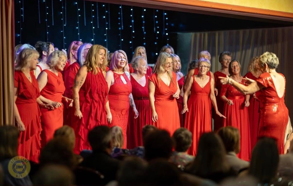 Red Rock A Cappella women in red gowns at indoor venue