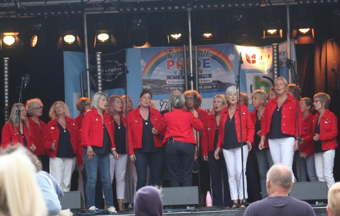 Red Rock A Cappella members celebrating on stage with Santa hats